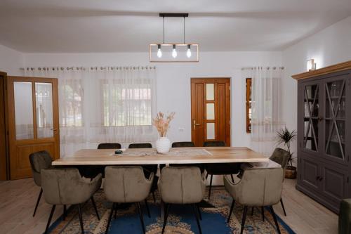 a dining room with a large wooden table and chairs at Casuta de sub deal 