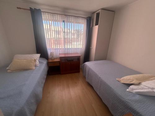 two twin beds in a room with a window at Casa playa moderna en las mejores playas de Chile in Bahia Inglesa