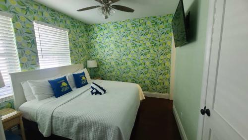 a bedroom with a bed with blue and green wallpaper at Duval Street Suite with pool in Key West