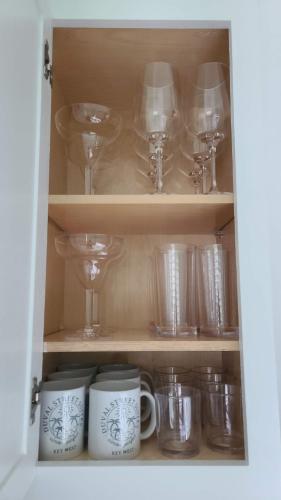 a cupboard filled with glasses and other glass items at Duval Street Suite with pool in Key West