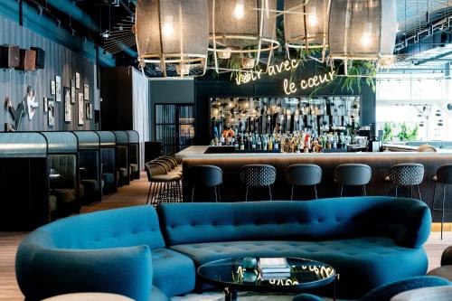 a lobby with blue couches and a bar at Motel One Paris-Porte de Versailles in Issy-les-Moulineaux