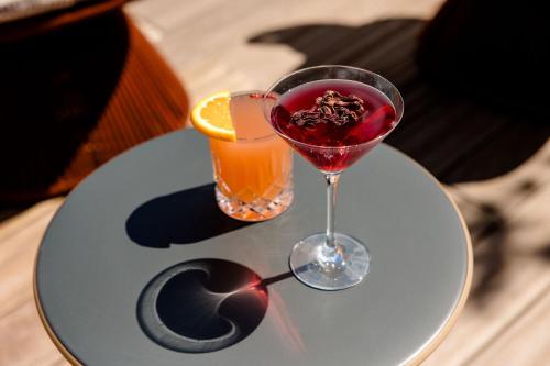 a table with a wine glass and a drink at Motel One Paris-Porte de Versailles in Issy-les-Moulineaux