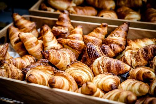 a bunch of croissants and other baked goods in trays at Motel One Paris-Porte de Versailles in Issy-les-Moulineaux