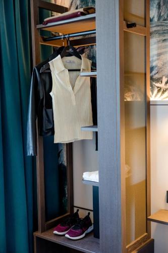 a closet with a shirt and shoes in it at Motel One Paris-Porte de Versailles in Issy-les-Moulineaux