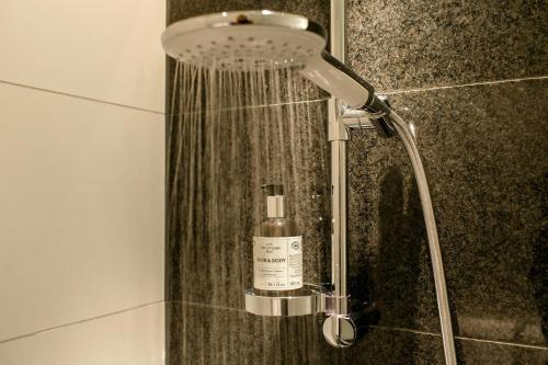 a shower in a bathroom with a bottle of soap at Motel One Paris-Porte de Versailles in Issy-les-Moulineaux