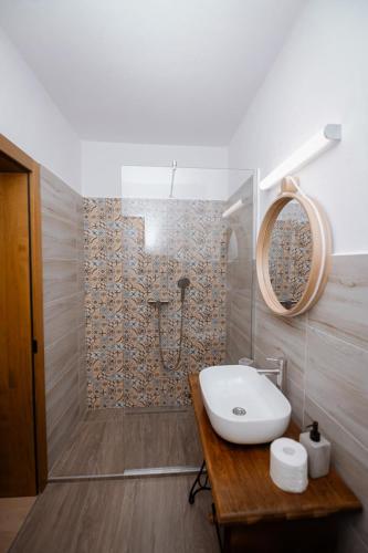 a bathroom with a sink and a shower at Casuta de sub deal in Tăuţi