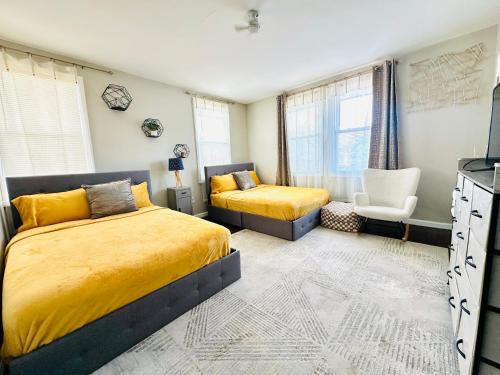 a bedroom with two beds and a chair at 41 Montrose Master Bedroom in Newark
