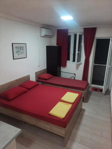 a bedroom with two beds with red and yellow pillows at Hris-An in Star Dojran