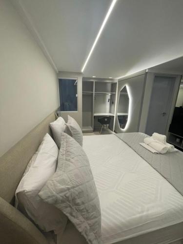 a bedroom with a large bed with white sheets and pillows at Troodon Park Hotel in Sousa
