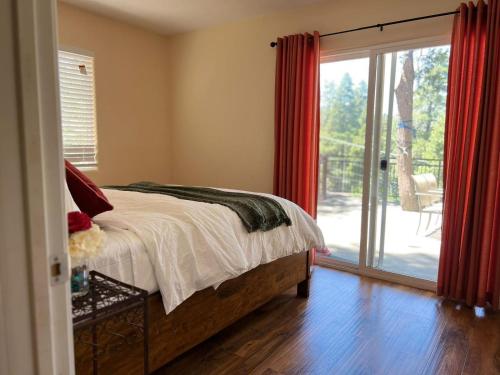 ein Schlafzimmer mit einem Bett und einer Glasschiebetür in der Unterkunft Cozy Cabin in Crestline