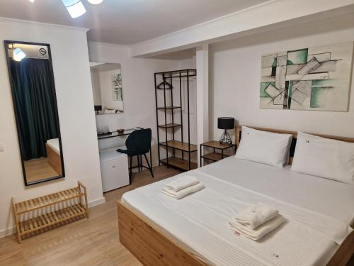 a bedroom with a bed with towels on it at Vila Andora in Eforie Nord