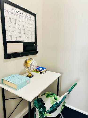 a desk with a calendar on the wall next to a chair at 41 Montrose Master Bedroom in Newark