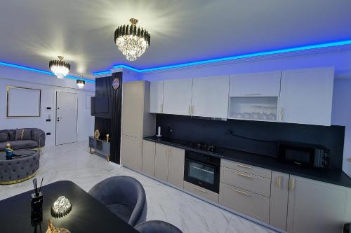 a kitchen with white cabinets and a blue ceiling at Aparthotel C37 - Alezzi Odyssey Pool & Spa Resort in Mamaia Nord