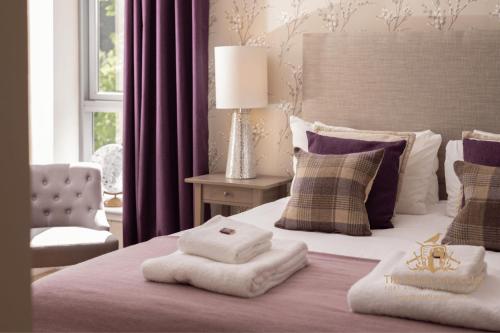 a bedroom with a bed with towels on it at The Highland Club in Fort Augustus
