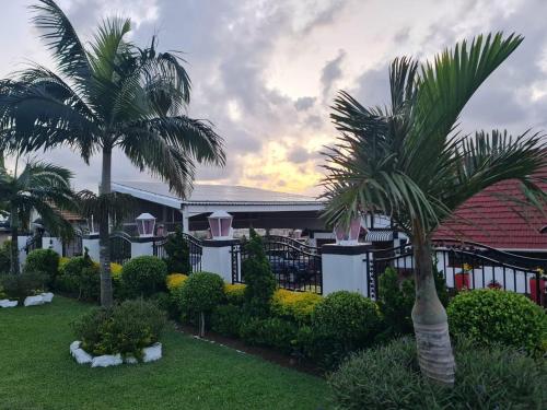 two palm trees in front of a building at Orca Estate Guesthouse Self-catering Accommodation in Durban