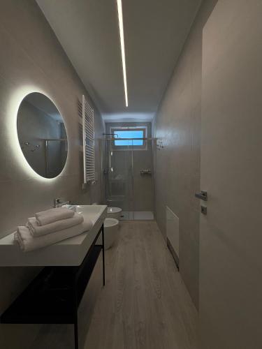 a bathroom with a sink and a toilet and a mirror at Residence Corallina in Caorle