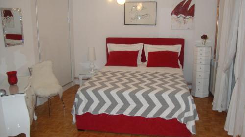 Schlafzimmer mit einem roten und weißen Bett und einem Stuhl in der Unterkunft Apartments Vodice Marica in Vodice