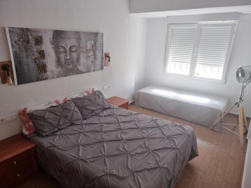 a bedroom with a bed and a window with a picture at LA NUEVA TIERRA Apartamentos Turísticos in Elda