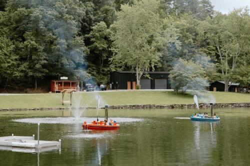 two boats in a lake with people in them at Creekside Modern Tiny Home - Firepit - Racoon Cabin in Gatlinburg