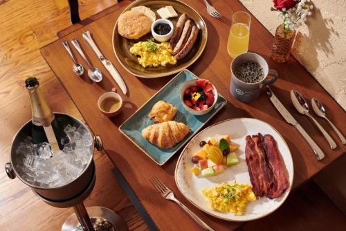 a wooden table with two plates of breakfast food at Rancho Caymus Inn in Rutherford