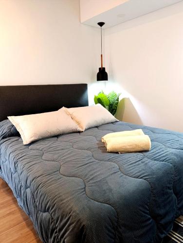 a bedroom with a bed with a blue blanket at Hermoso Departamento en alquiler, Edificio Agora I, Villa Rosa in La Lonja