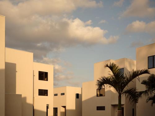 a building with a palm tree in front of it at URUUMI Onna Pool Villa ｳﾙｳﾐ ｵﾝﾅ ﾌﾟｰﾙ ｳﾞｨﾗ -公式- in Onna