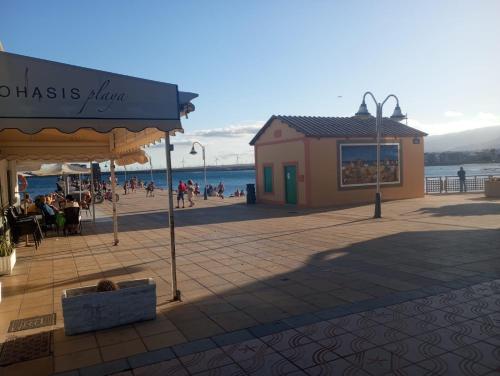 Un edificio en un paseo marítimo con gente en la playa. en Brisa B, en Agüimes