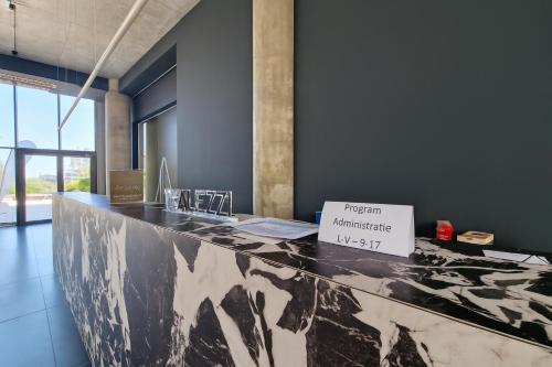 a black and white counter with a sign on it at Aparthotel C37 - Alezzi Odyssey Pool & Spa Resort in Mamaia Nord