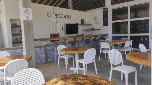 a restaurant with wooden tables and white chairs at PH Las Islas Punta Barco Viejo a 3 min de Coronado in San José
