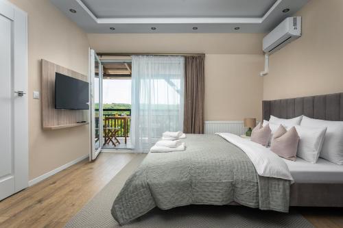a bedroom with a large bed and a television at Dolce Apartmanház in Eger