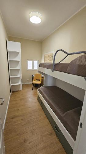 a room with two bunk beds and a yellow chair at Il filo di Arianna Ischia Sapri in Sapri