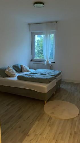 a bed in a room with a window and a table at Wohnung Ideal für Ihr Projekt in Mülheim an der Ruhr
