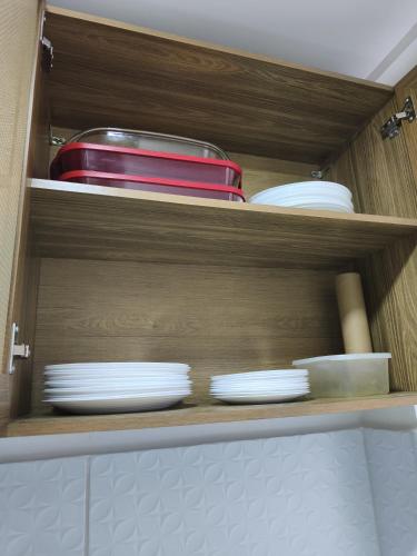 a cabinet filled with plates and bowls and dishes at Apartamento Inteiro Mobiliado in Parnamirim