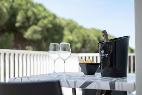 two wine glasses and a bag on a table at Hotel La Pineta in Follonica