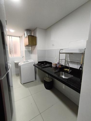 a small kitchen with a sink and a refrigerator at Apartamento Inteiro Mobiliado in Parnamirim