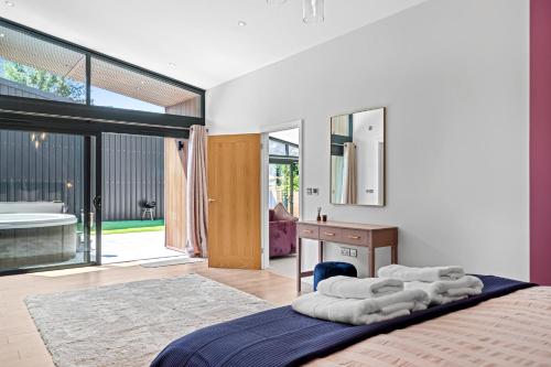 a bedroom with a bed and a desk and a bathroom at The Wren - Luxury Retreat in Abergavenny
