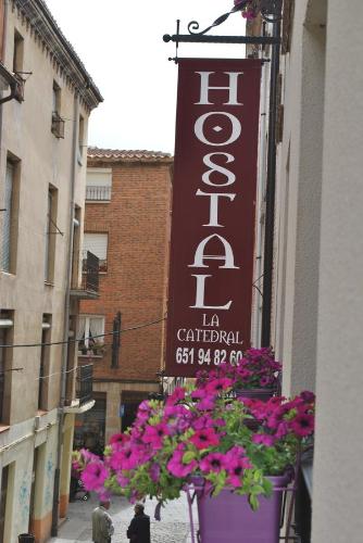 a sign on the side of a building with flowers at Hostal la Catedral in Santo Domingo de la Calzada