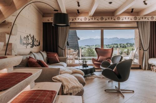 a living room with a couch and chairs and a large window at Tatra Bjerge View in Zakopane