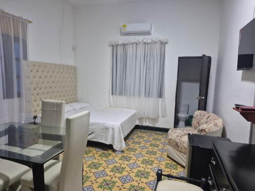 a small room with a bed and a table and chair at Hostal La Villa in Estación El Salto