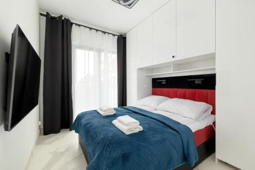 a bedroom with a bed with two towels on it at Amber Baltic Apartment by Solarento in Niechorze