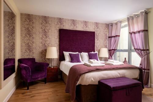 a bedroom with a large bed with purple accents at The Highland Club in Fort Augustus