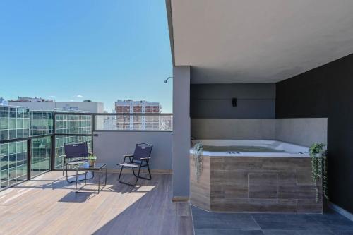 - un balcon avec un bain à remous au-dessus d'un bâtiment dans l'établissement Fliphaus Mansion Mitre 'A' - 4 pax Duplex Gym & Jacuzzi, à Buenos Aires