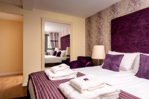 a bedroom with a bed with towels on it at The Highland Club in Fort Augustus