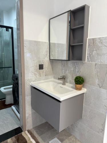 Un baño con un lavabo blanco y un espejo. en City homes, en Nairobi