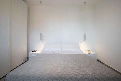 a bedroom with a large white bed in a room at Hotel La Pineta in Follonica