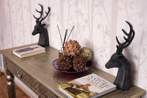 a table with two deer heads and a book at The Highland Club in Fort Augustus