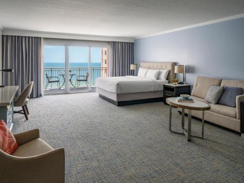 a hotel room with a bed and a couch and a table at Hyatt Regency Clearwater Beach Resort & Spa in Clearwater Beach