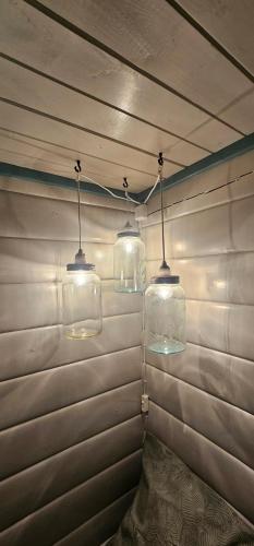 a room with three glass lights on the wall at Fredbo in Melåa