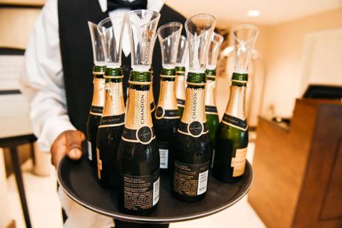 a waiter holding a tray with wine bottles and glasses at DoubleTree by Hilton New Orleans in New Orleans