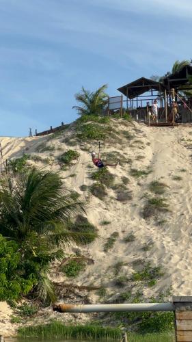 a sandy beach with palm trees on top of it at Chalé sítio Cumbe in Aracati